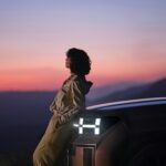 a woman sitting on the hood of a car