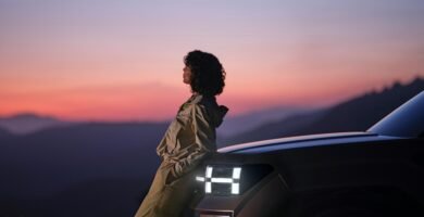 a woman sitting on the hood of a car